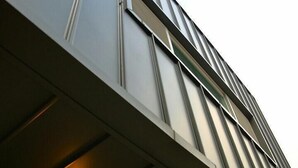 Un edificio moderno con facciata in pietra e rivestimento in metallo.