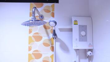 Una ducha con cabezal de ducha de mano y panel de control en la pared.