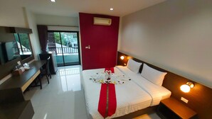 A hotel room with a bed, bedside table, desk, and a television. - The Siri Place (Udon Thani)