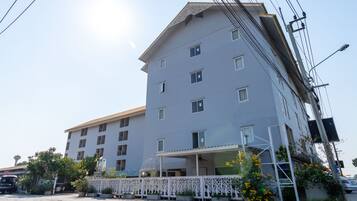 A multi-story hotel with a flat roof and a covered entrance.
