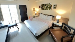 Een hotelkamer met een bed, nachtkastjes, een bureau en een stoel.