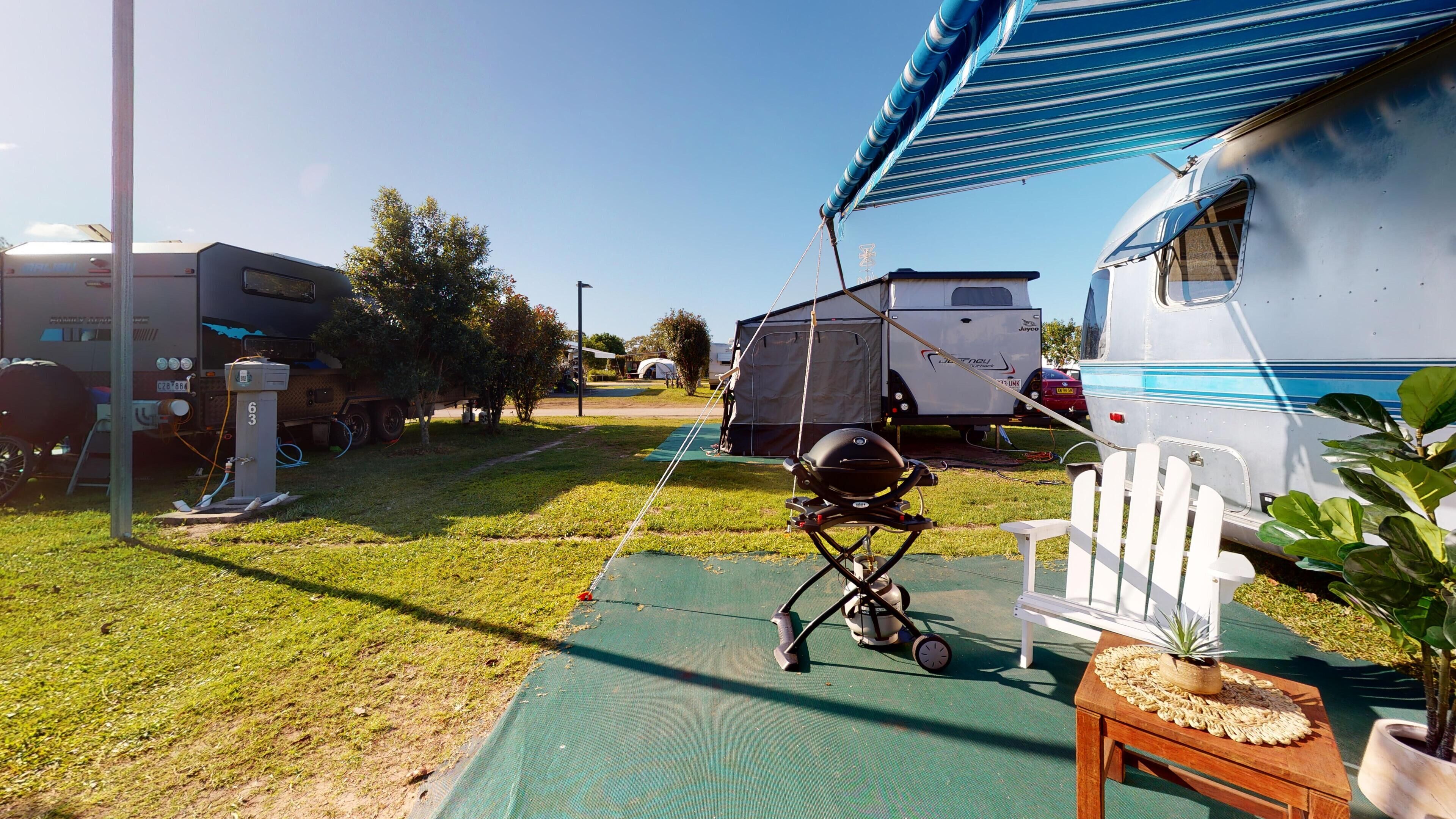 Un terrain de camping équipé de mobil-homes, d’un barbecue et d’emplacements pour tentes.