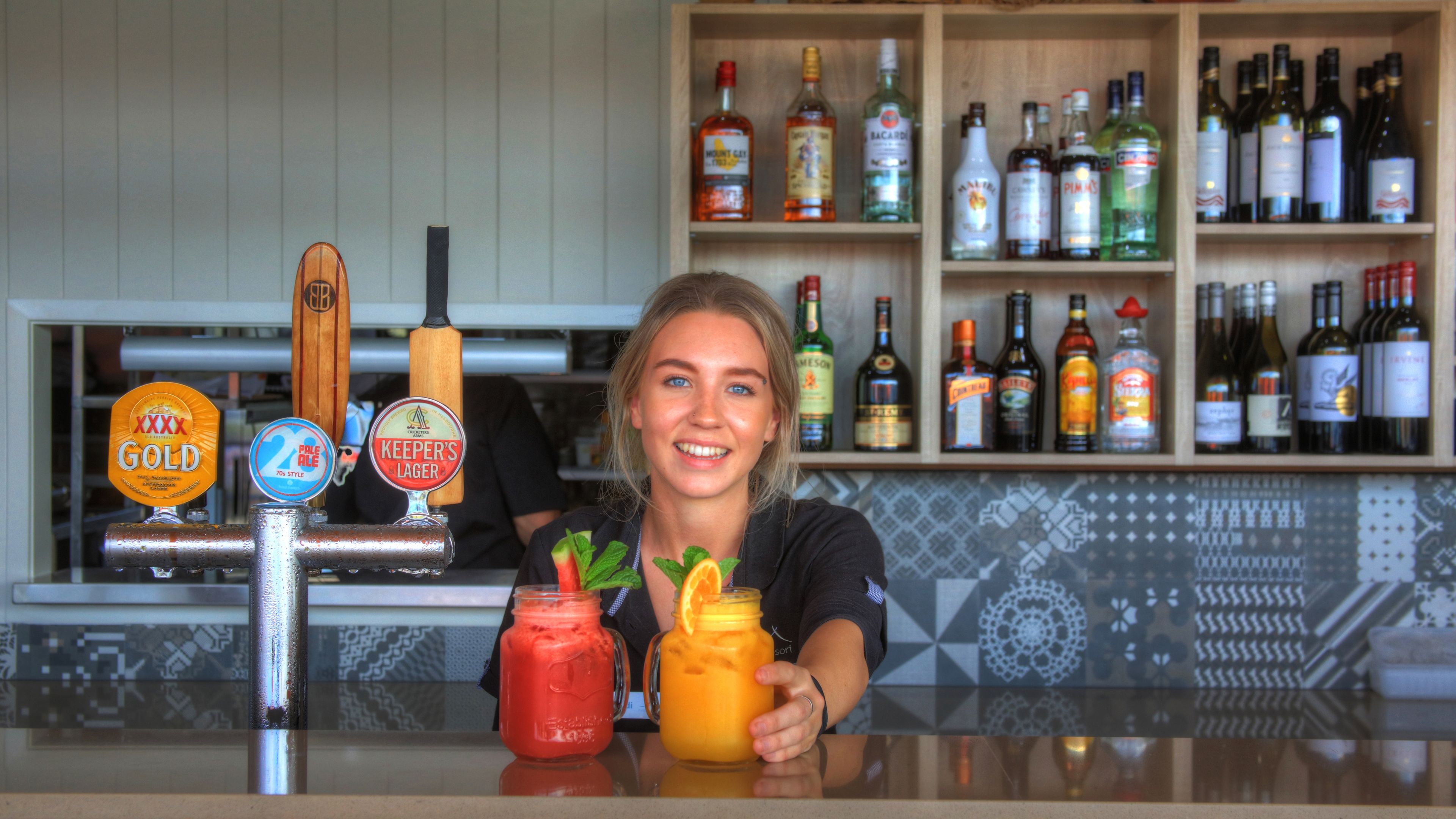 Un espace bar avec un assortiment de bouteilles d’alcool et un robinet proposant différentes sortes de bière.