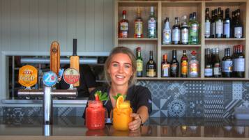 Un espace bar avec un assortiment de bouteilles d’alcool et un robinet proposant différentes sortes de bière.