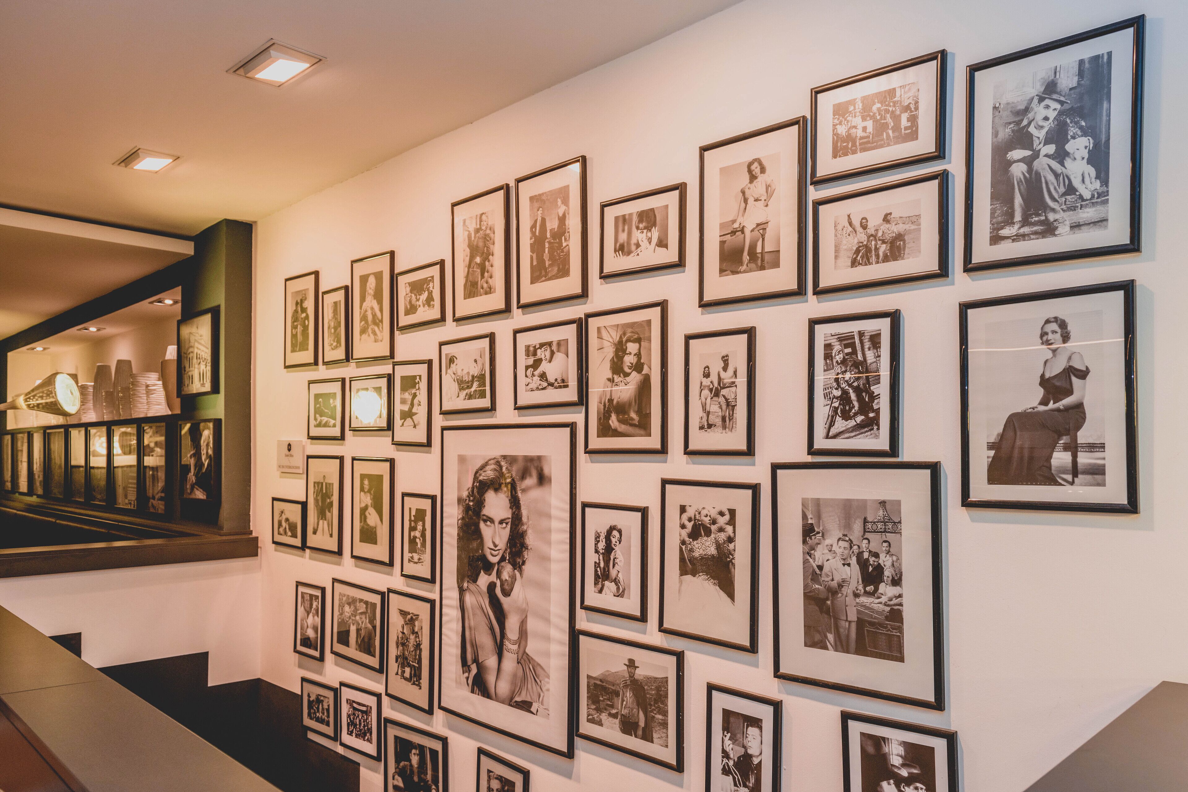 A gallery wall with numerous framed photographs.