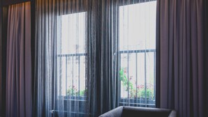 A room with a large window, a chair, and a small table.