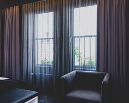 A room with a large window, a chair, and a small table.