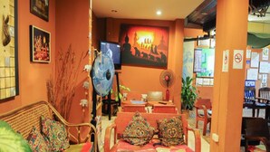 A cozy room with a sofa, chairs, a television, and a reception desk. - All In 1 Guesthouse Chiang Mai (Chiang Mai)