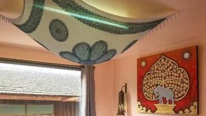 A bedroom with a bed, a window, and a wall decoration. - All In 1 Guesthouse Chiang Mai (Chiang Mai)