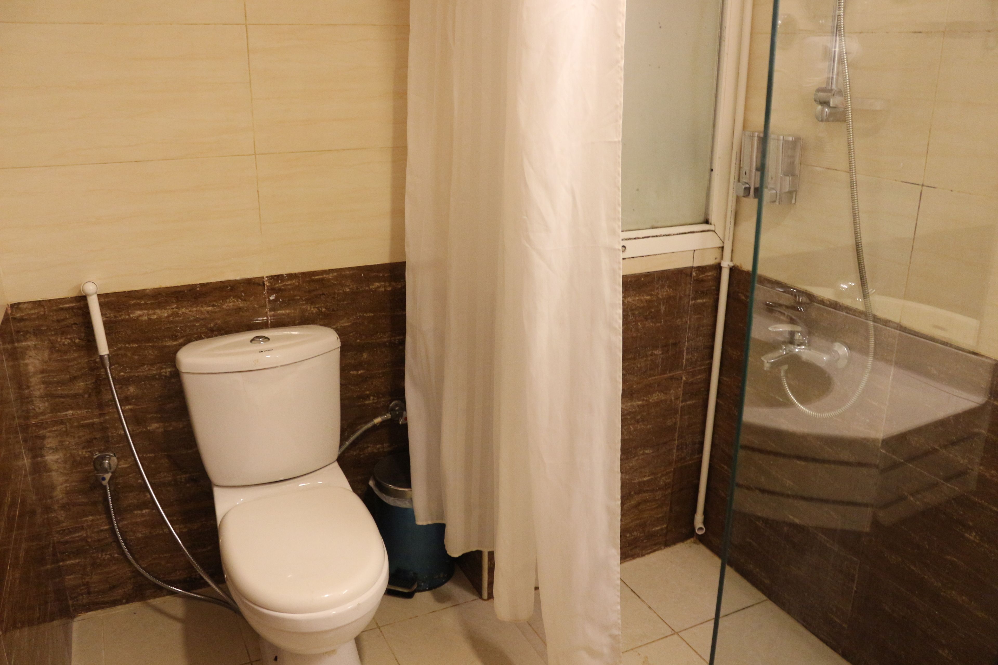 A bathroom with a toilet, shower, and sink.