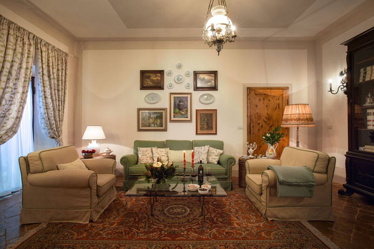 A living room with two sofas, a coffee table, and a chandelier.