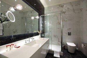 A modern bathroom with a large mirror, a glass shower enclosure, and a white sink. - Pera Residence (Istanbul)