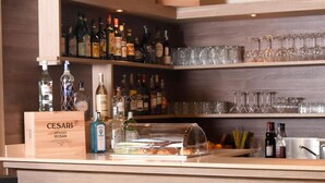A bar area with shelves of liquor bottles and glasses. - Agriturismo Ponte di Rialto (Crema)