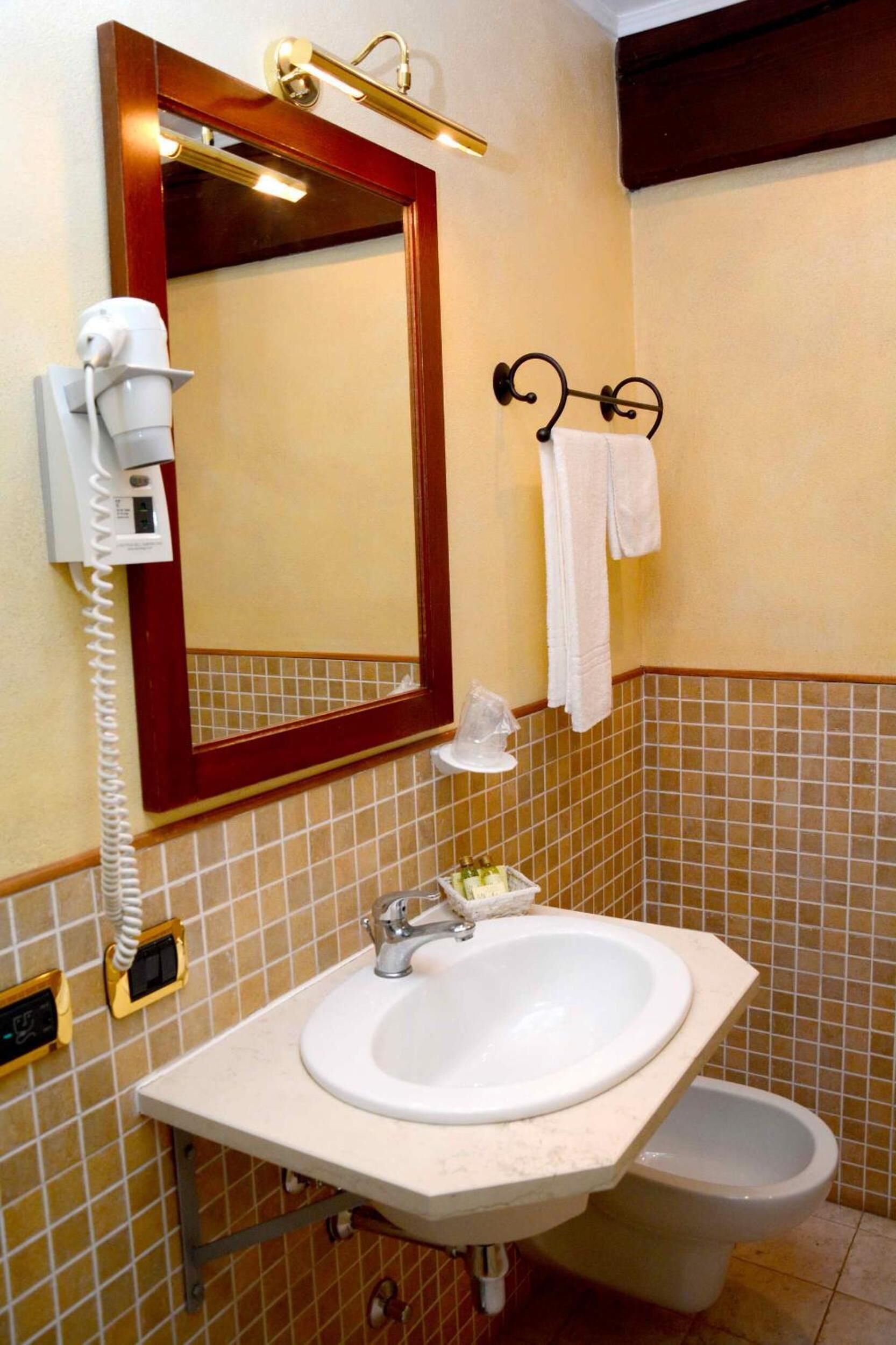 A bathroom with a sink, mirror, and towel rack.