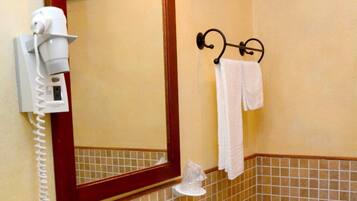 A bathroom with a sink, mirror, and towel rack.