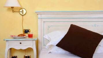 Une chambre d’hôtel avec un lit, une table de chevet avec une lampe, une assiette de nourriture et un verre de jus de fruits.