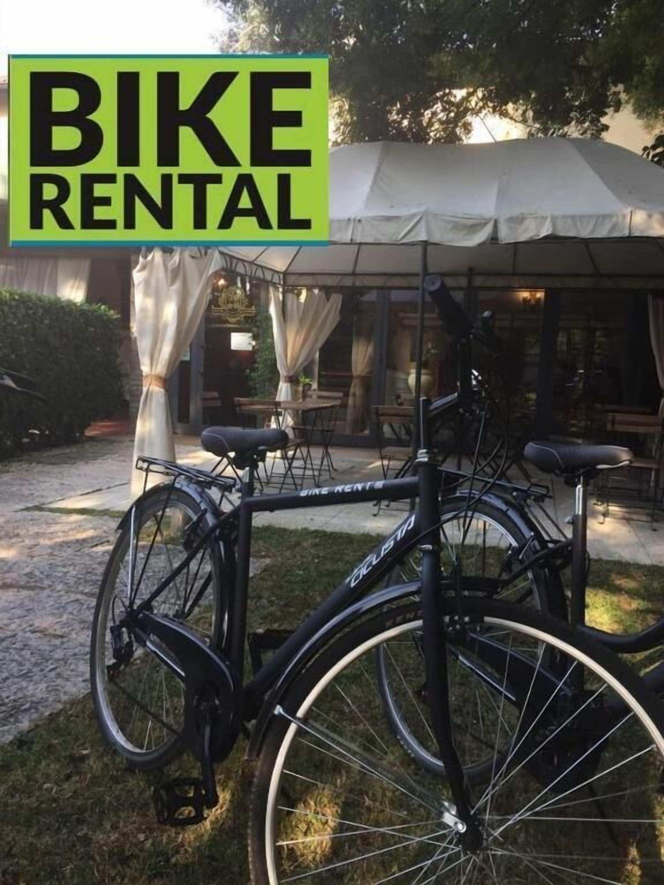 A bike rental service with two bicycles parked outside a building with a covered patio area.
