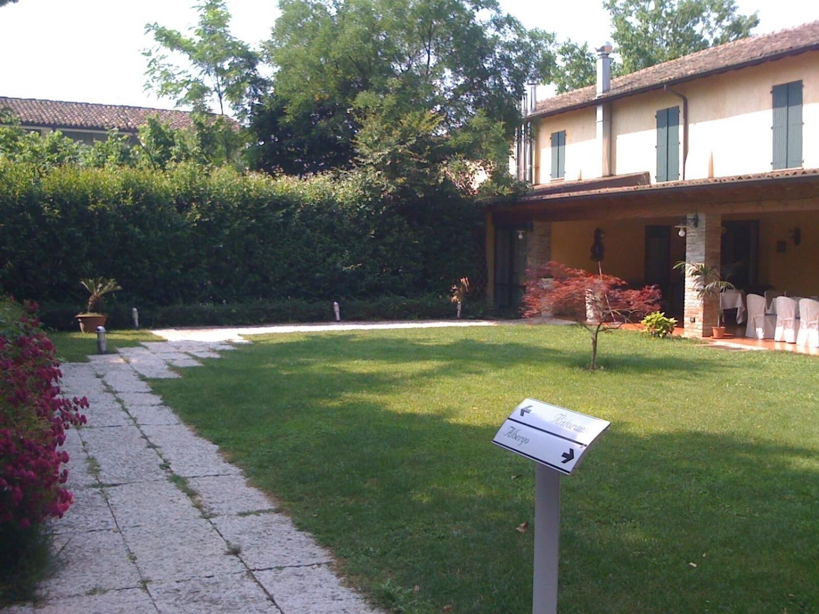 A courtyard with a stone pathway leading to a building with a tiled roof.