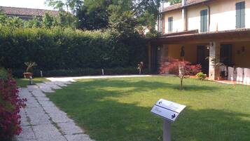 A courtyard with a stone pathway leading to a building with a tiled roof.