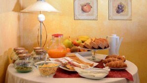 A breakfast buffet with various food items, a lamp, and framed pictures on the wall. - Albergo Antica Hostelleria (Crema)