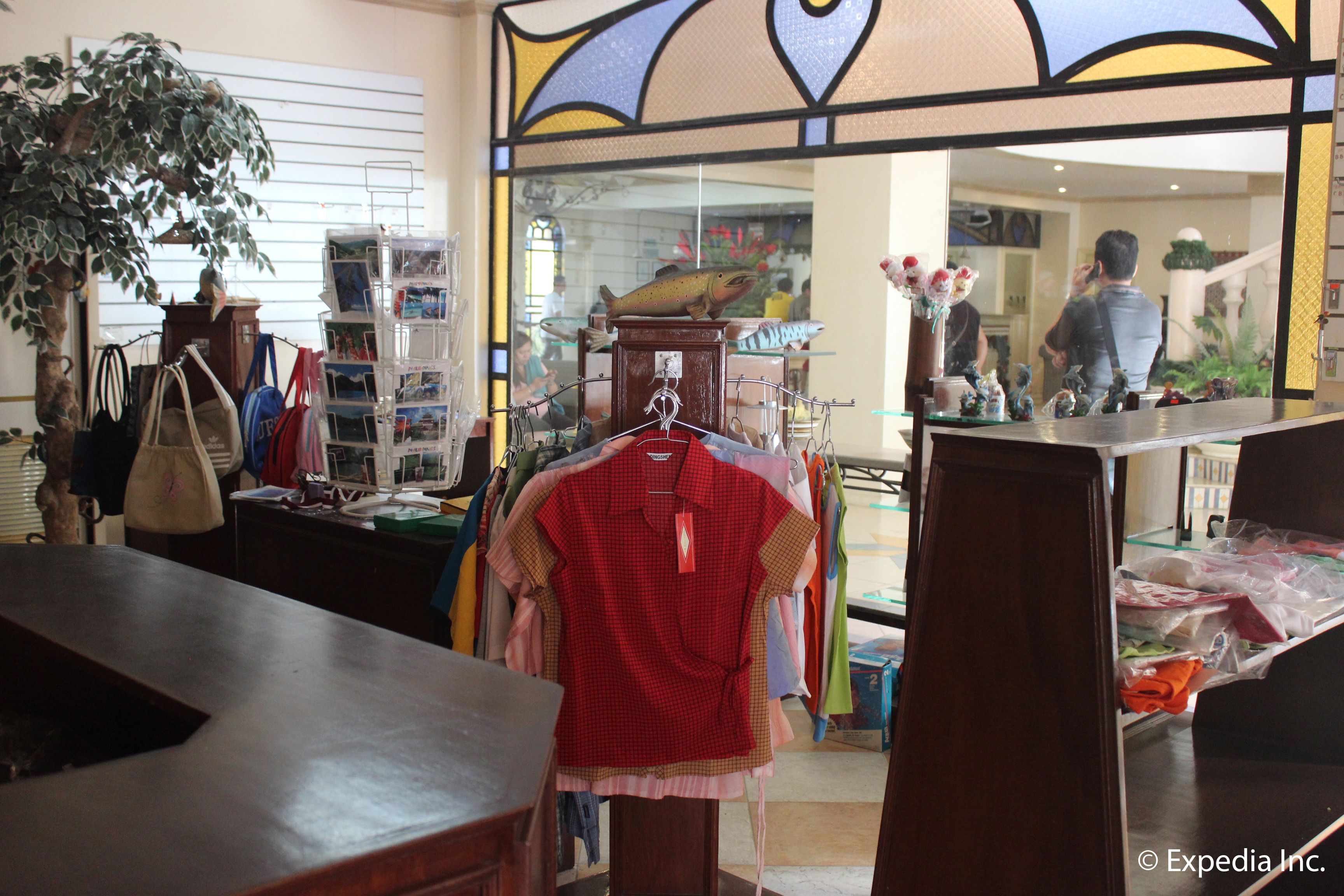 Una tienda de ropa con perchas llenas de prendas y una exhibición de bolsos.