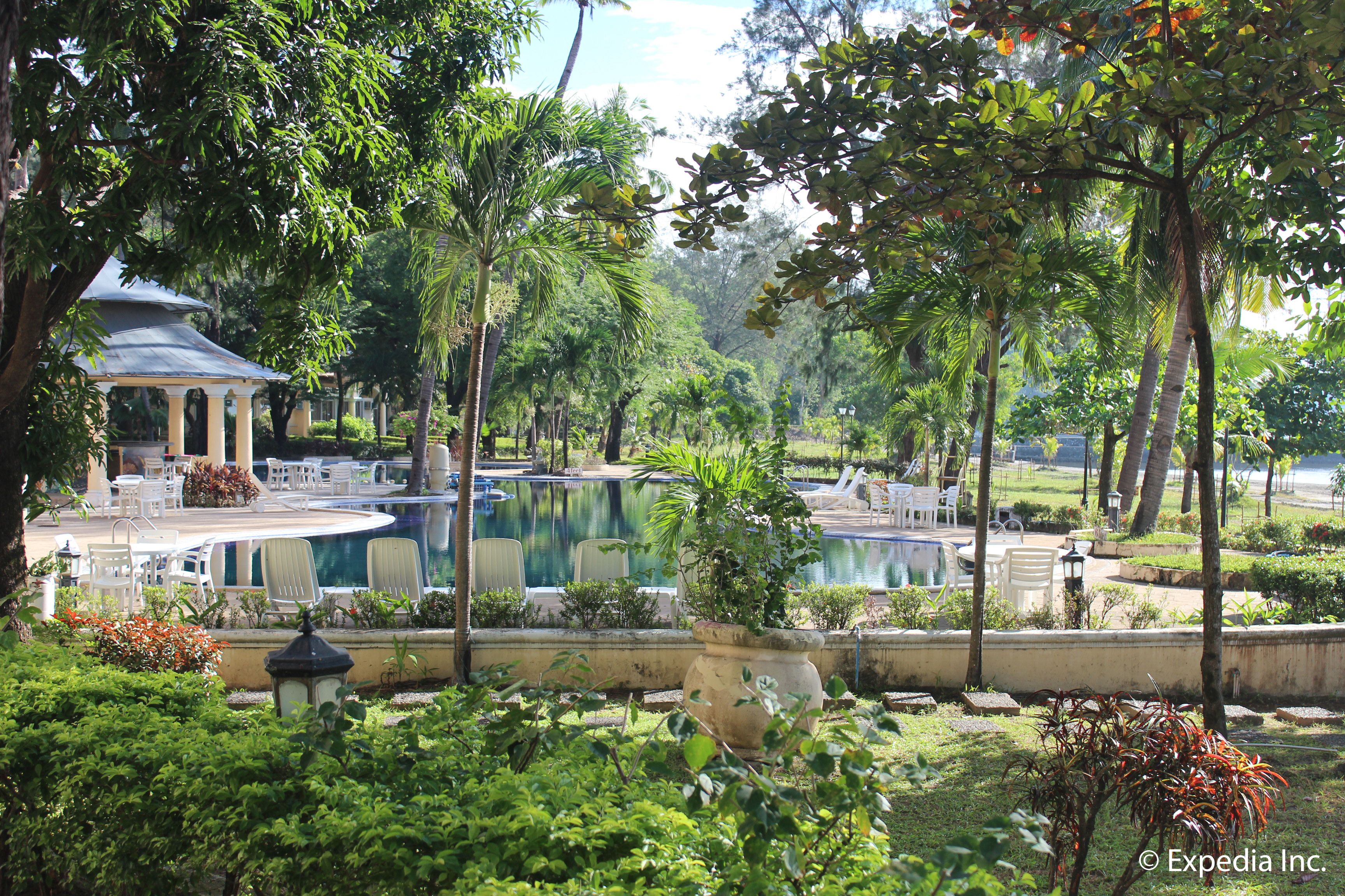 A pool area with lounge chairs and a gazebo.