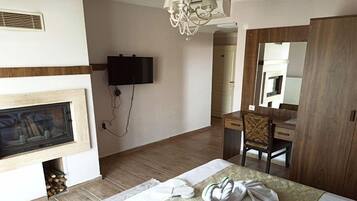 Un dormitorio con chimenea, televisor montado en la pared, armario de madera y espejo.