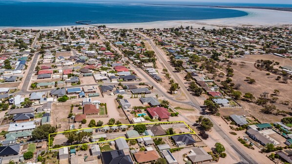 An aerial view of a coastal residential area with houses, roads, and a beach. - Moonta Bay Accommodation (Moonta Bay)
