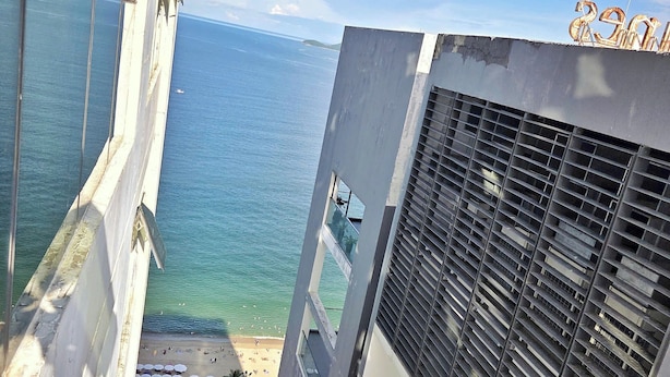 Ein Hochhaus mit Blick auf Strand und Meer.