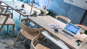 A modern meeting room with wooden furniture, a laptop, and a smartphone on a table. - Shao Guang 188 (Yuchi)