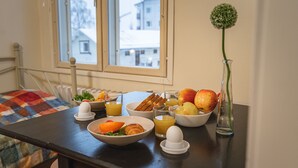 Ein Esstisch mit verschiedenen Speisen, einer Obstschale und einem Glas Orangensaft.