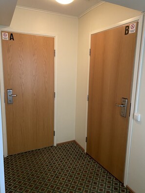 Two wooden doors labeled A and B, each with a keyhole and a door handle. - Aakenus Apartments (Rovaniemi)