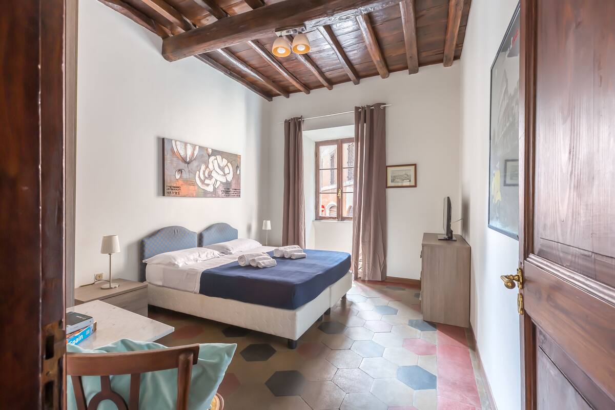 A bedroom with a bed, a desk, a chair, and a wardrobe.