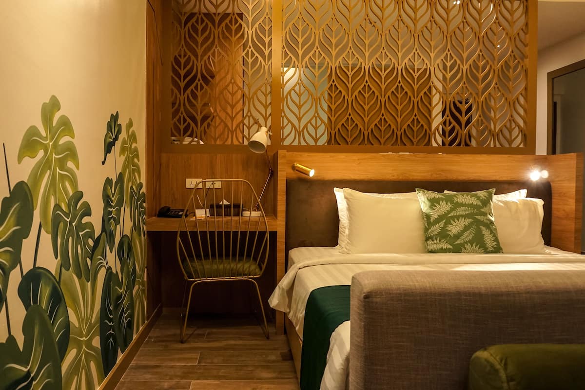 A hotel room with a bed, a desk, and a chair.