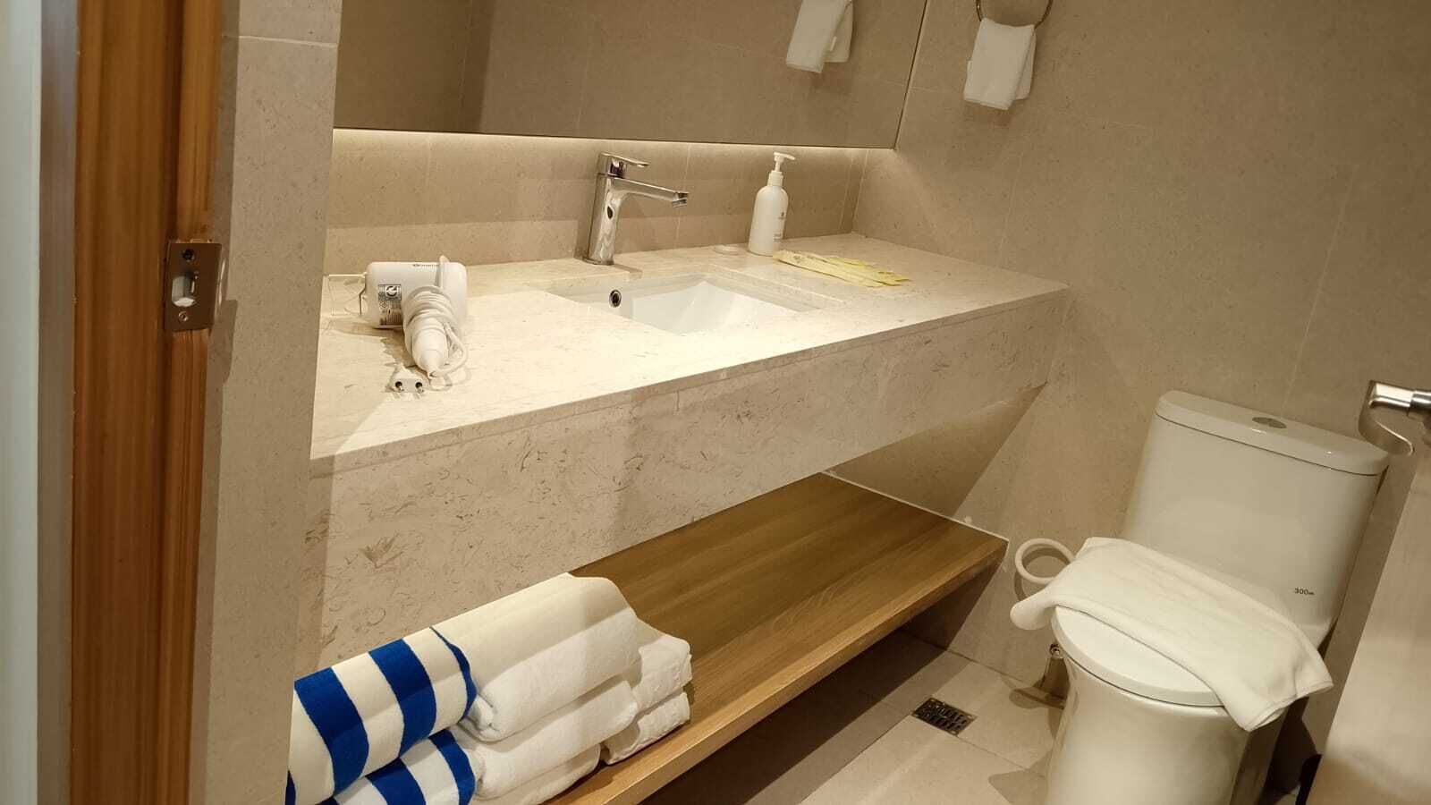 A bathroom with a sink, mirror, and toilet.