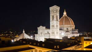 A historic building with a prominent tower and dome, surrounded by other structures. - Repubblica Firenze Luxury Apartments | UNA ESPERIENZE (Florence)