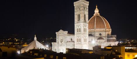A historic building with a prominent tower and dome, surrounded by other structures.