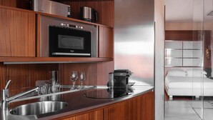 A modern kitchen with a built-in oven, a coffee maker, and a stainless steel sink. - Repubblica Firenze Luxury Apartments | UNA ESPERIENZE (Florence)
