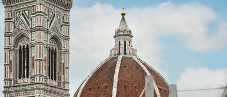 Un edificio histórico con una cúpula grande y una torre alta de diseños intrincados.