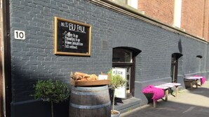 A black brick building with a sign reading "No 10 BIJ PAUL" and a wooden barrel with bread. - Nine(T)Teen B&B (Amsterdam)