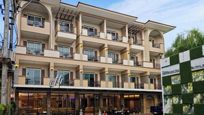 A multi-story hotel with balconies, a ground-level restaurant, and a parking area. - Hi Chiangrai Hotel (Chiang Rai)