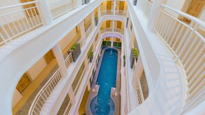 A multi-level indoor swimming pool with multiple balconies and railings. - Hi Chiangrai Hotel (Chiang Rai)