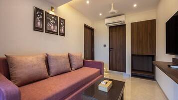 A modern living room with a sofa, a coffee table, and framed artwork on the wall.
