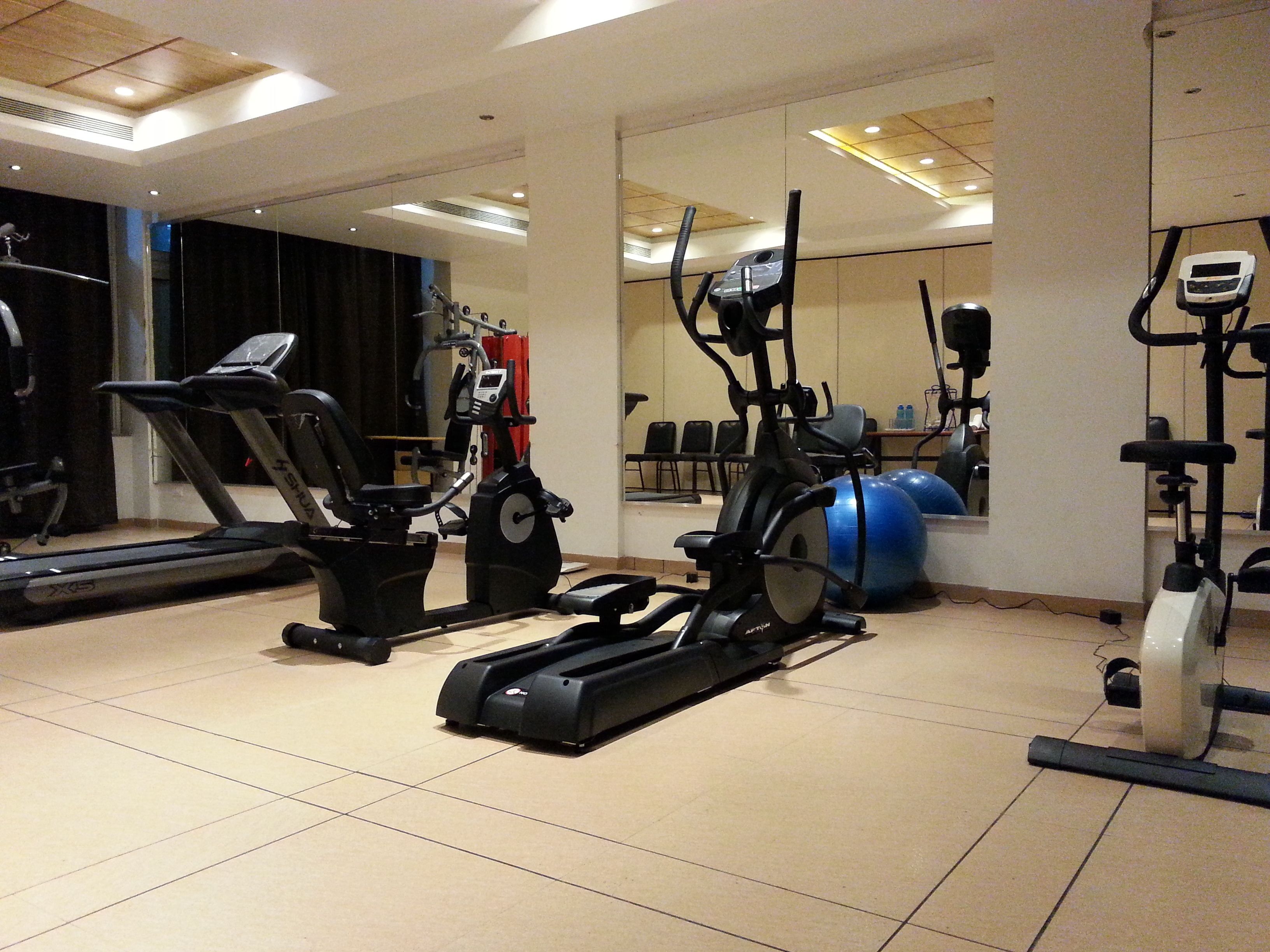A gym with various exercise equipment, including treadmills and elliptical machines.