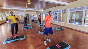 A spacious indoor gym with multiple exercise mats and dumbbells. - Wash and Wills Hotel (Mbale)