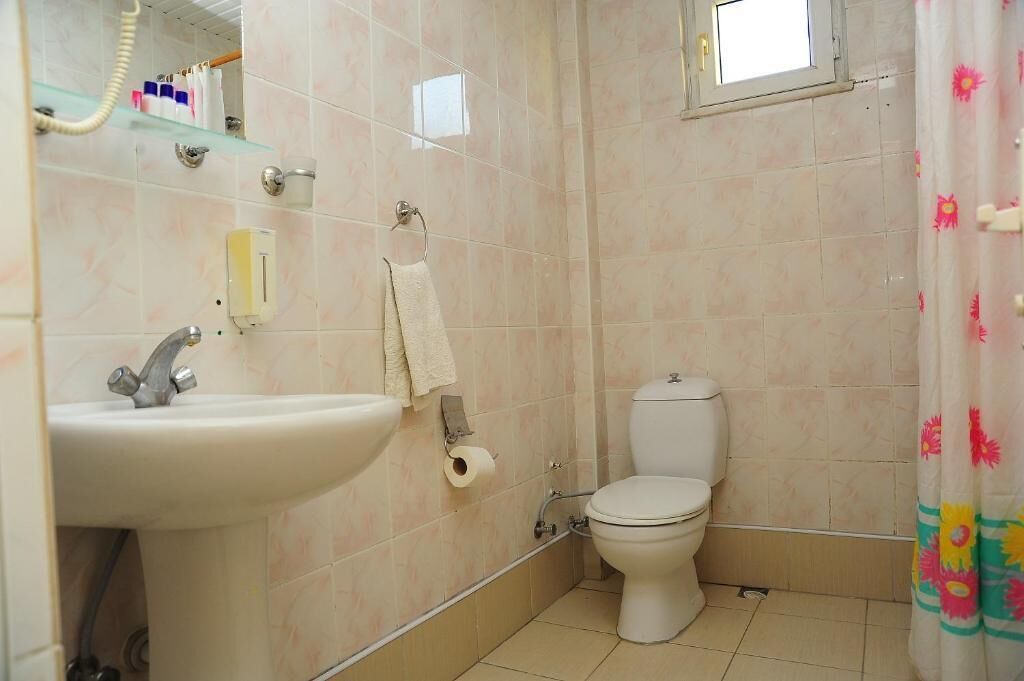 A bathroom with a sink, toilet, and shower curtain.