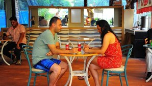 A couple seated at a round table with chairs, a small table, and a beverage. - Best Life Apart Hotel (Alanya)