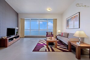Premier Apartment, 1 Bedroom | Living area | 40-inch TV with satellite channels, iPod dock - The Curve Hotel (Doha)