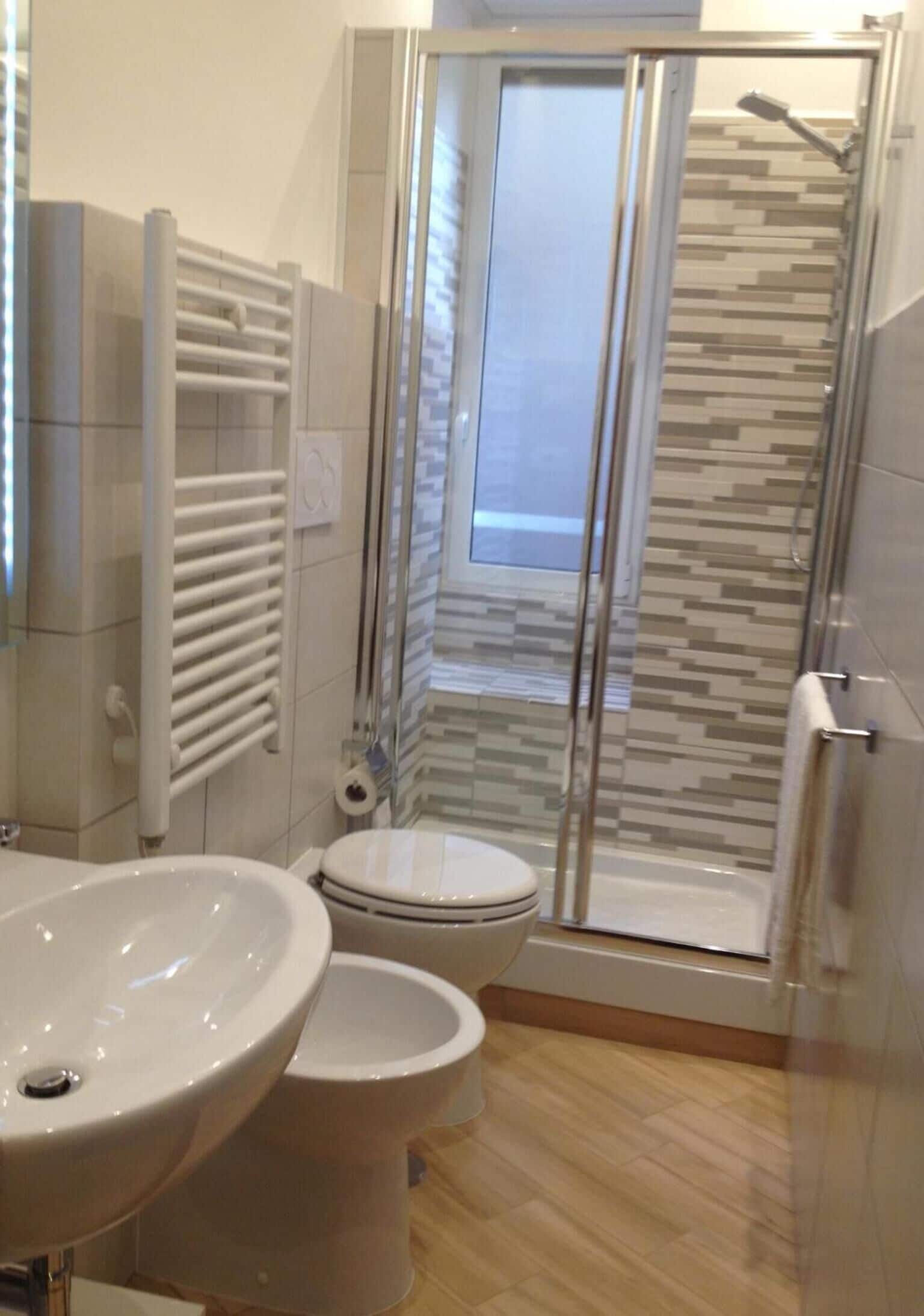A bathroom with a shower, toilet, and sink.