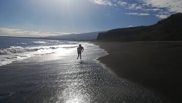 Une plage où une personne se promène le long du rivage.